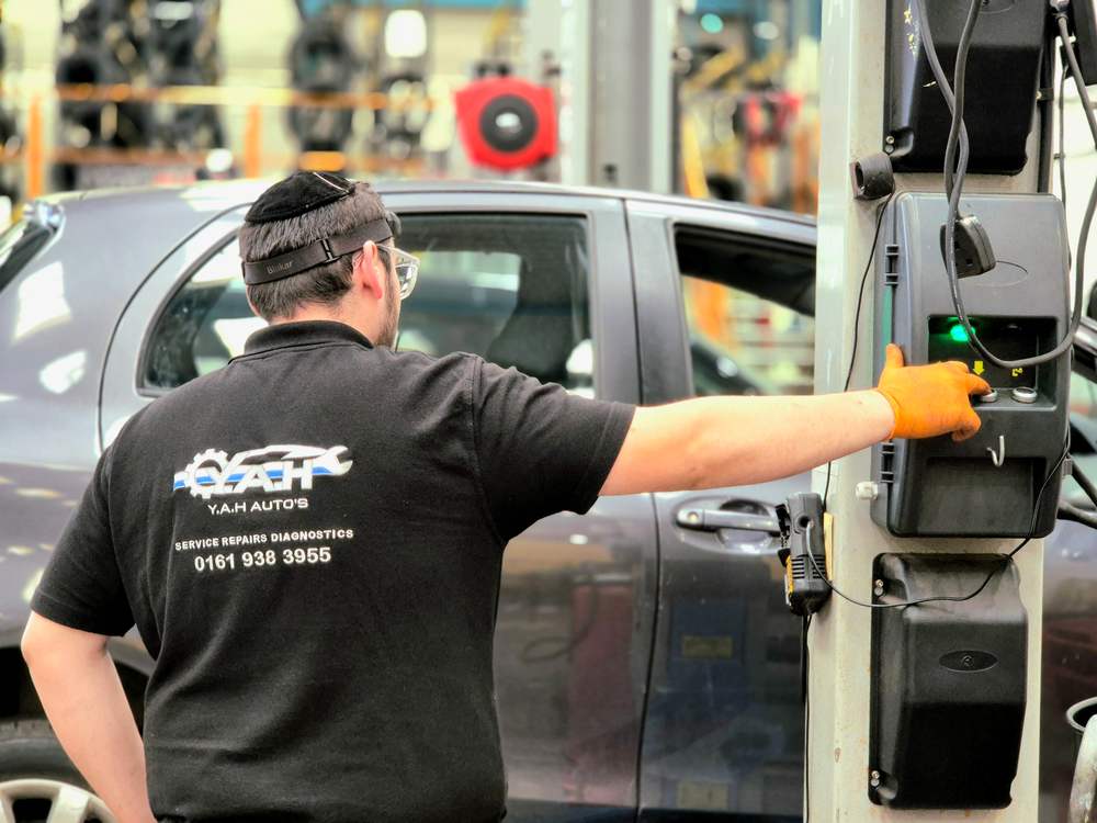 Mechanic operating a car lift in a garage